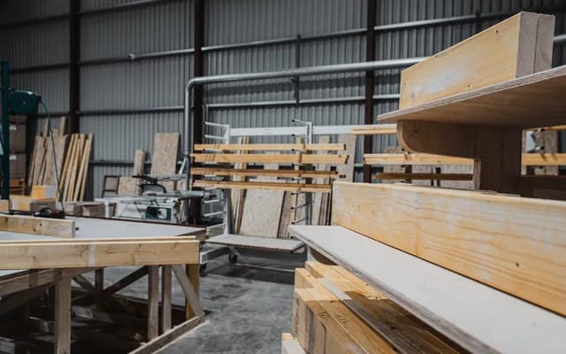 A woodworking shop with benches and stacked boards