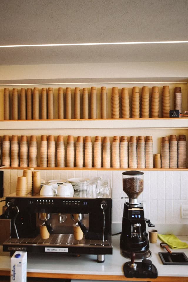 Stacks of paper coffee cups on café shelves