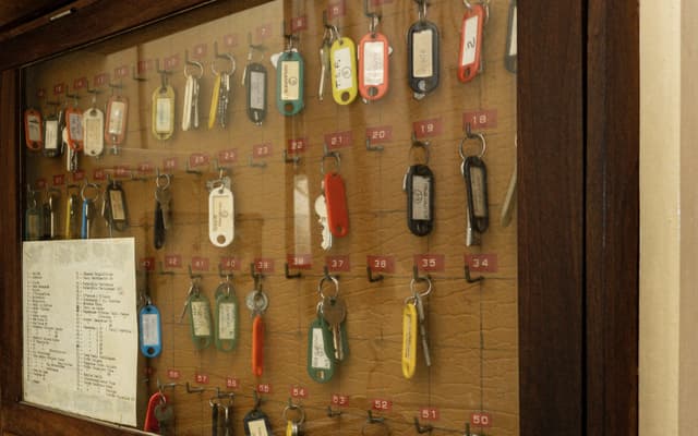 A key cabinet: tagged keys on numbered hooks and a typed list of rooms